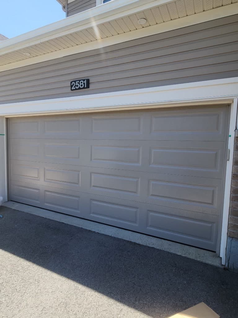 Taupe raised-panel garage door installed on a Stittsville home, West Ottawa